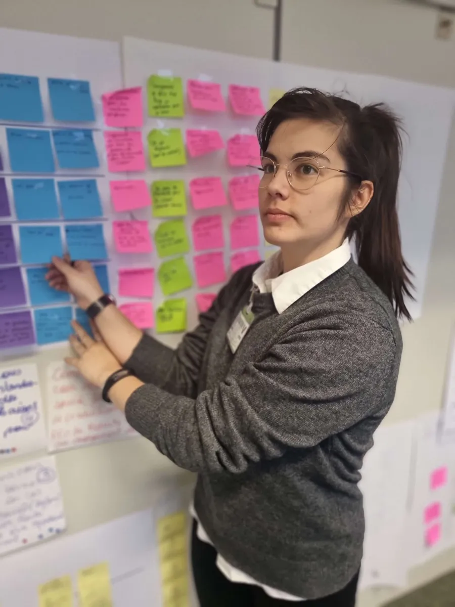 Ilana en atelier devant des post-it