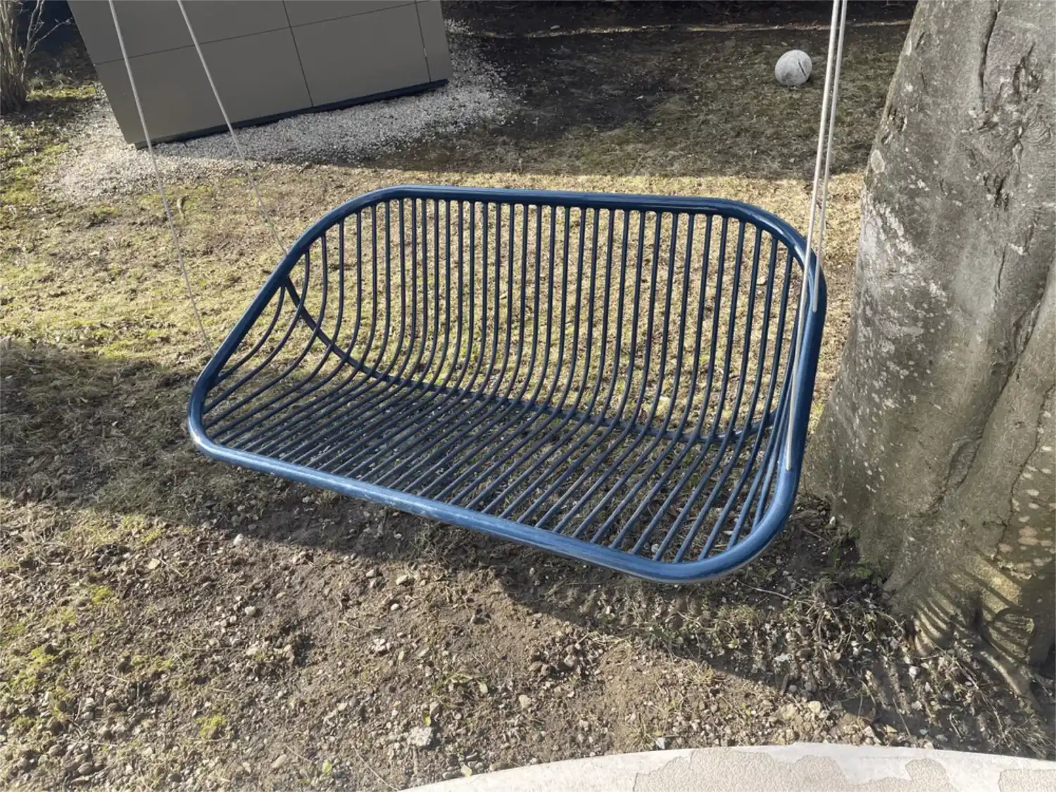 Glaenzendes, dunkelbau lackiertes modernes Metallgestell einer Outdoor Schaukel der Designerin Paola Lenti