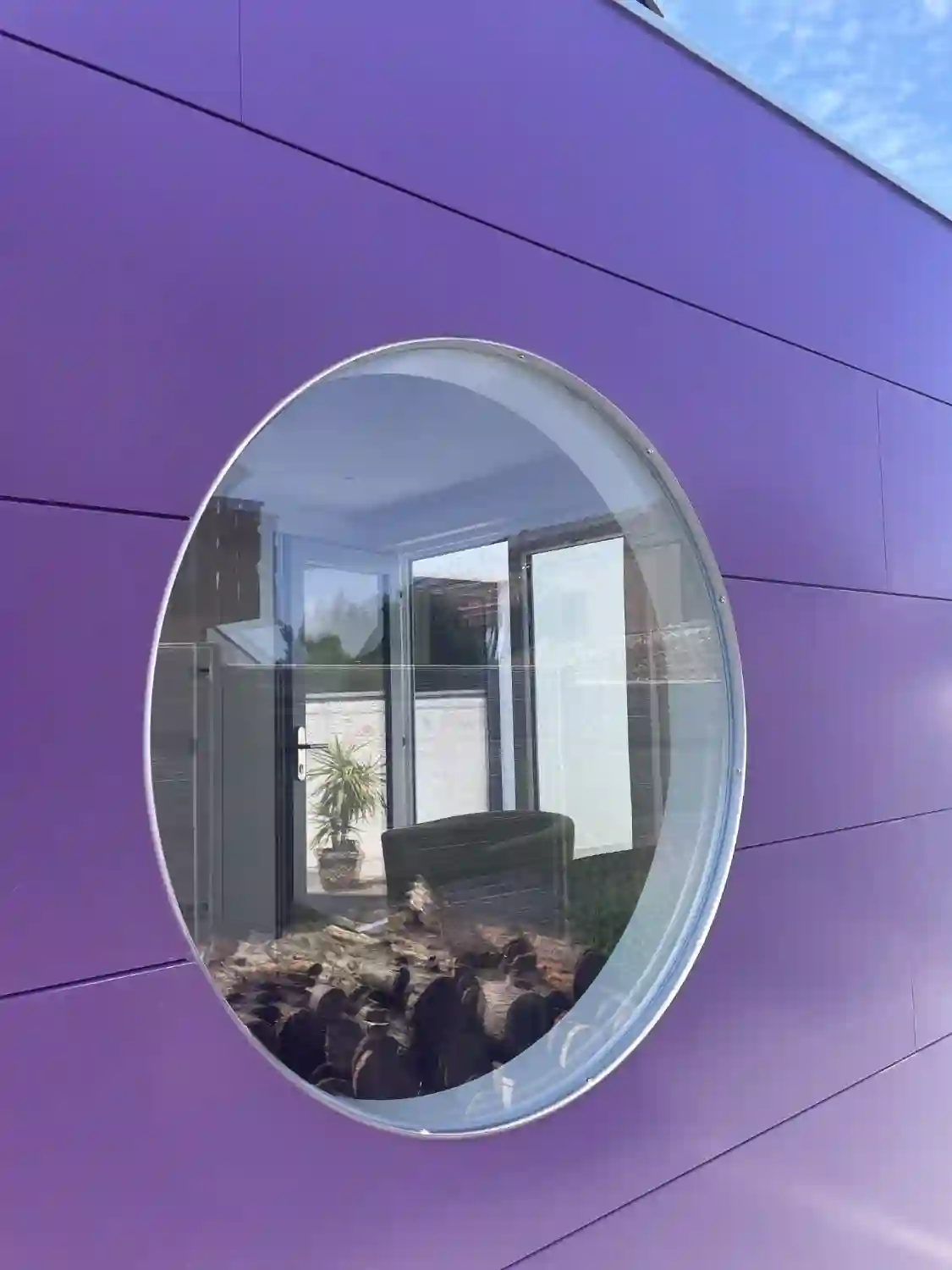 Detailblick auf lila gestrichene Holzfassade eines modernen Gartenhauses von Garten Kubus mit Rundfenster