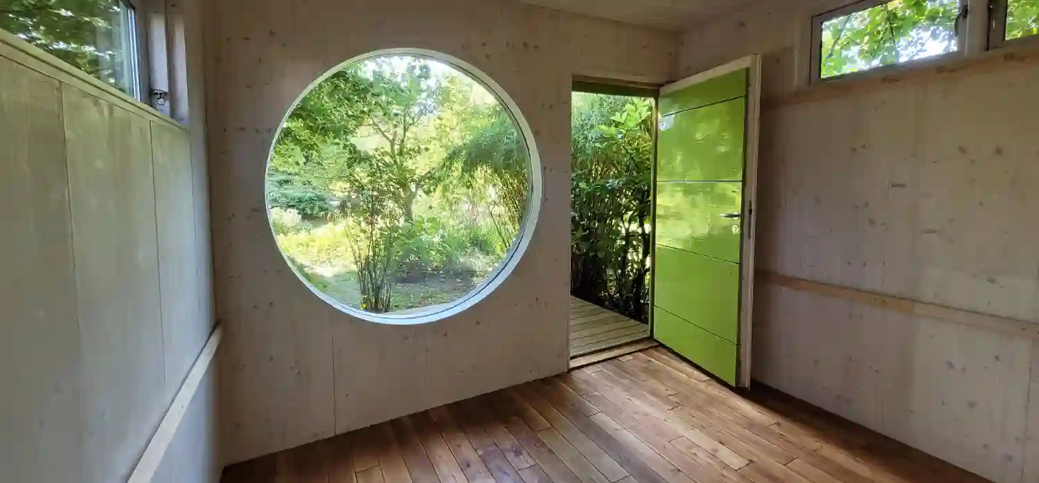 Im Innenraum eines isolierten Gartenhauses mit frisch renoviertem Eiche Parkett Boden und lasierten Holzwaenden