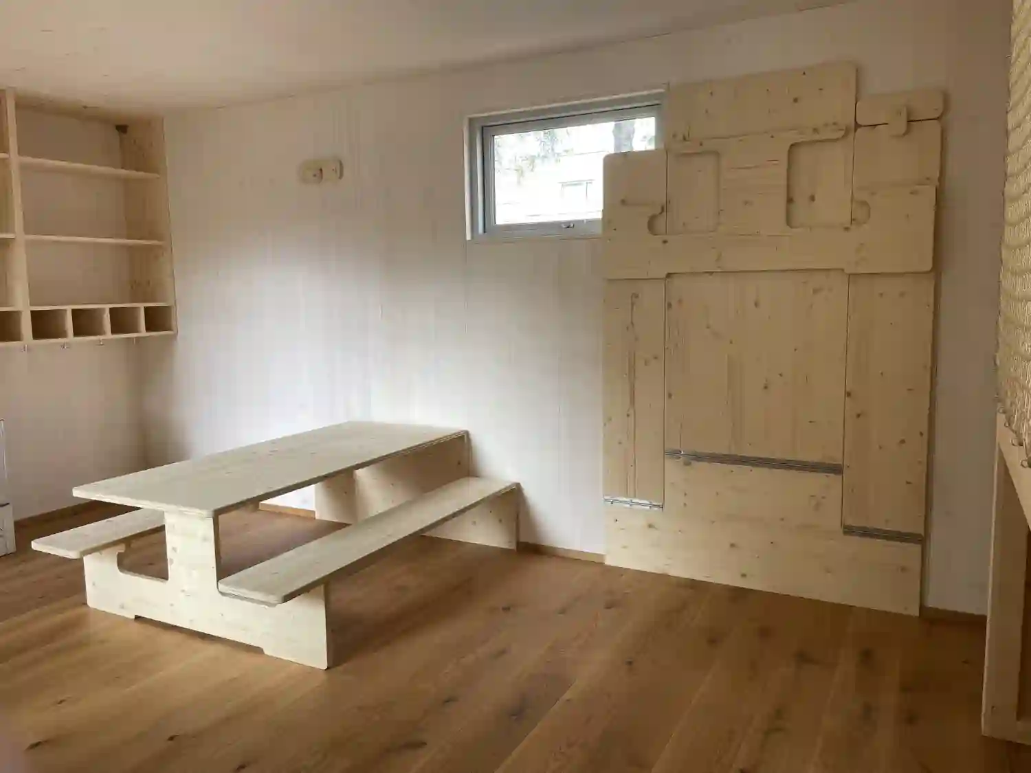 Blick auf klappbare Bank-Tisch Kombination aus Holz im isolierten Gartenhaus eines Kindergartens als Schutzraum