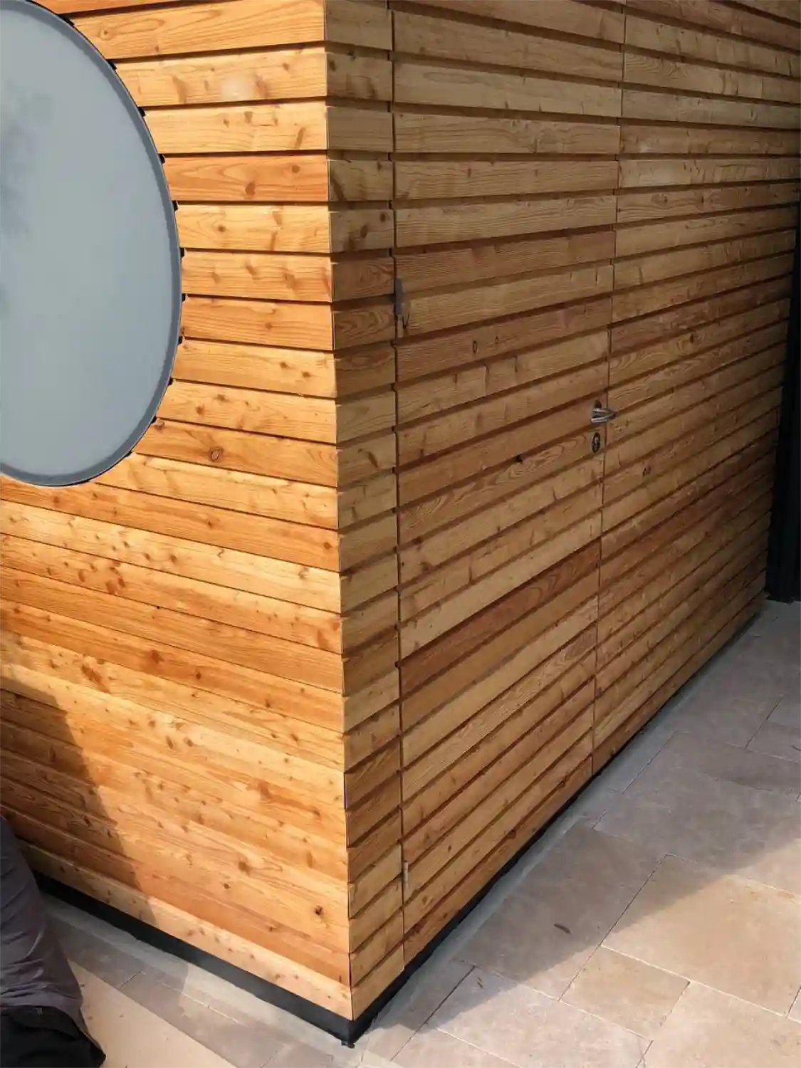 Detailblick auf Fassadenverkleidung eines Geraetehauses mit Laerche-Rhombus-Leisten