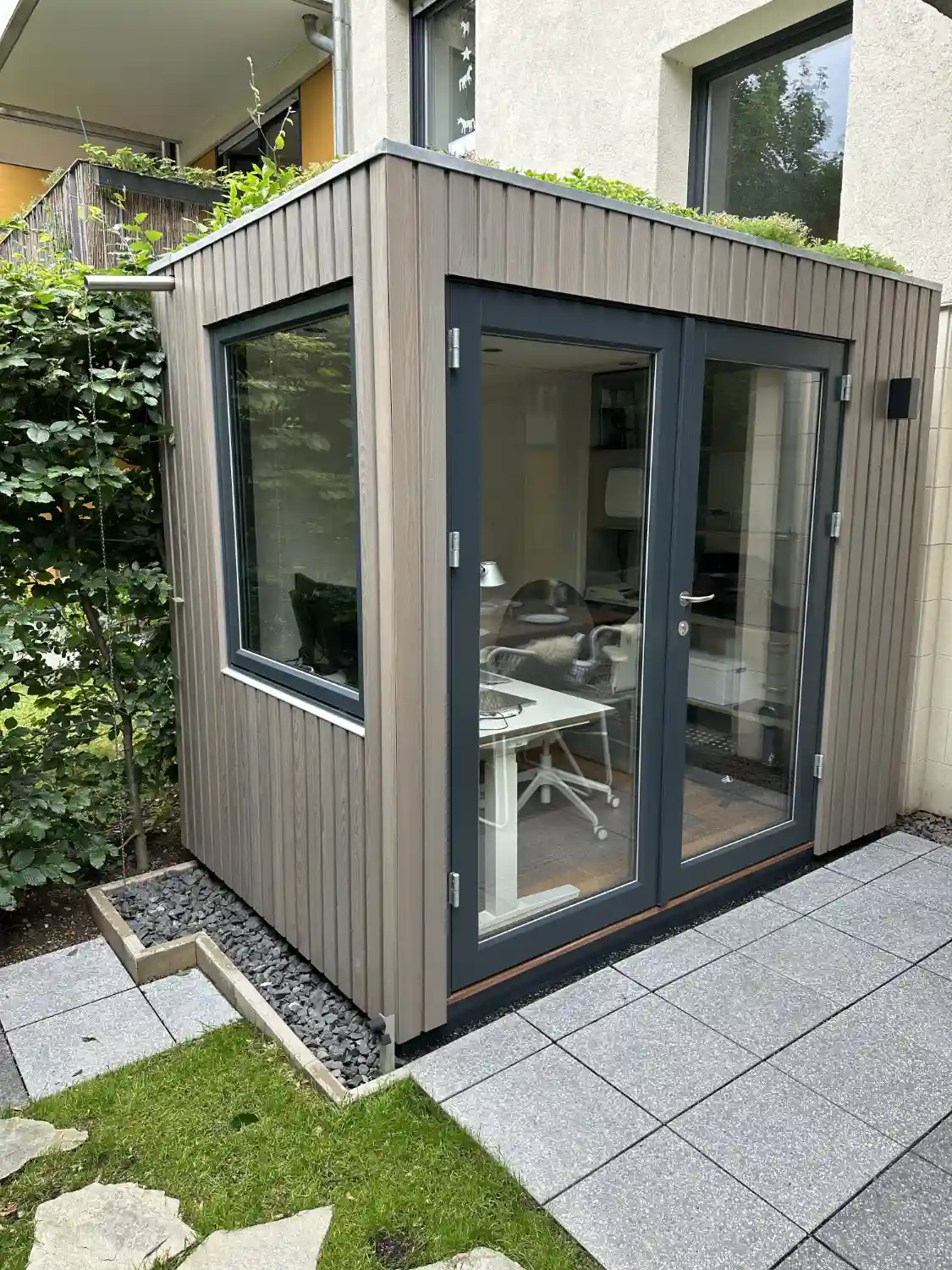 Design-Gartenbuero mit moderner Holzfassade aus Laerche Leisten, senkrecht verschraubt und mit Vergrauungslasur