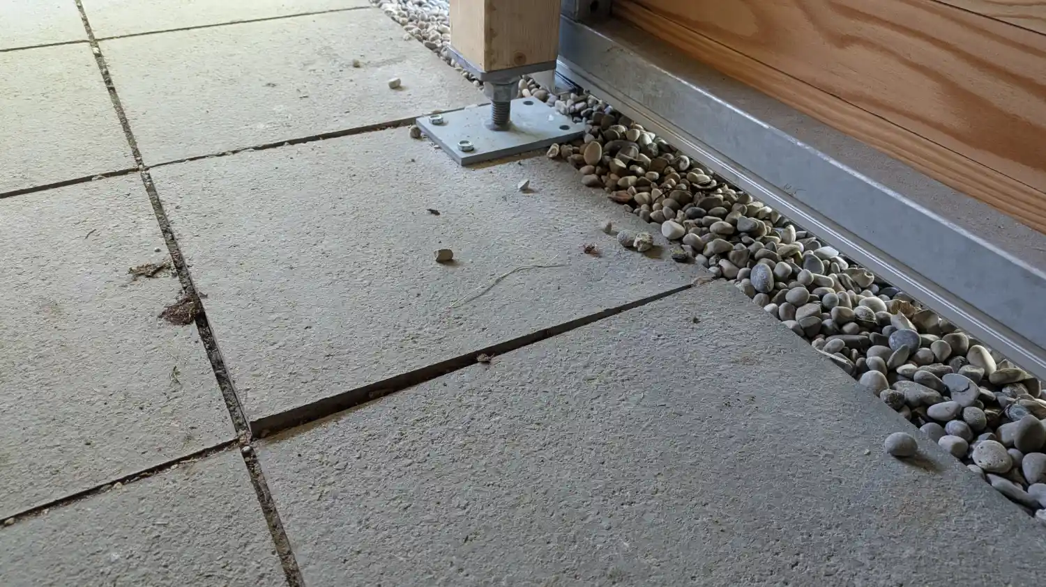 Detailblick auf fehlerhaftes Plattenfundament, Stuetze der Terrassenueberdachung ist ungleich montiert und Platte sinkt ab