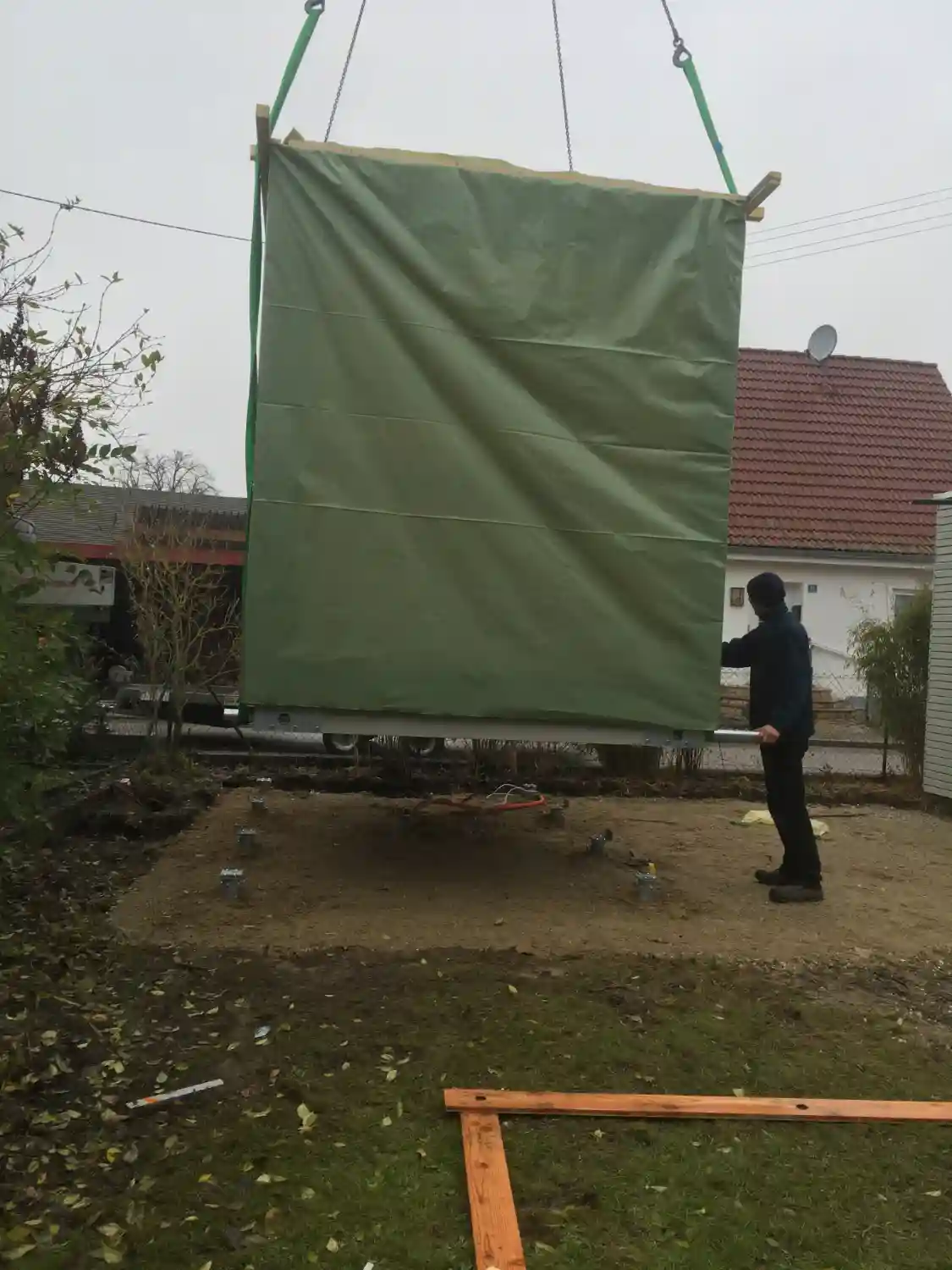Vormontiertes Gartenhaus wird per Ladekran auf frisch eingedrehte Krinner-Schraubfundamente gesetzt