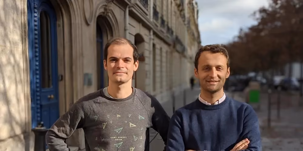 two men standing in front of a building