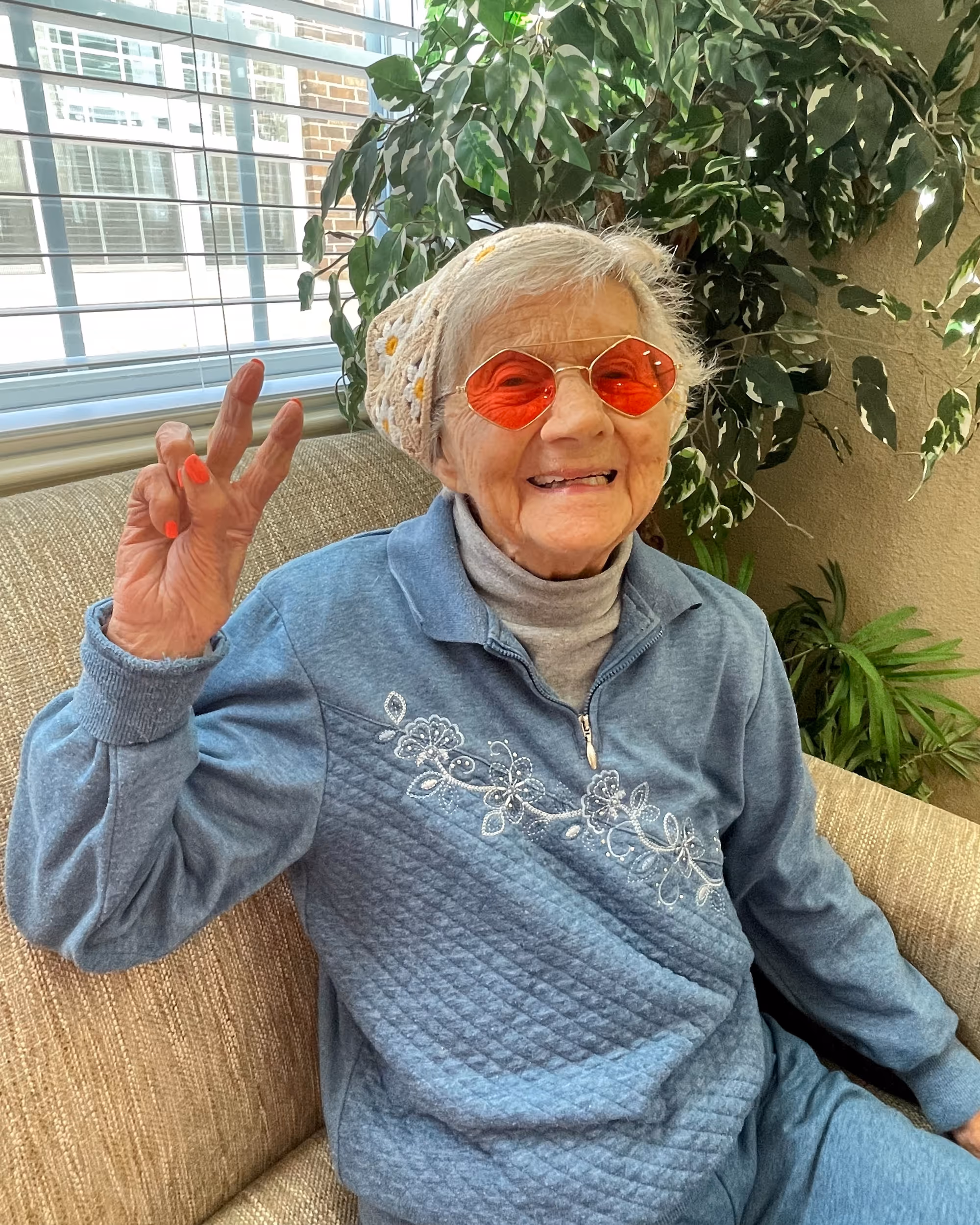 A Resident celebrating Decade Day in bright red round glasses