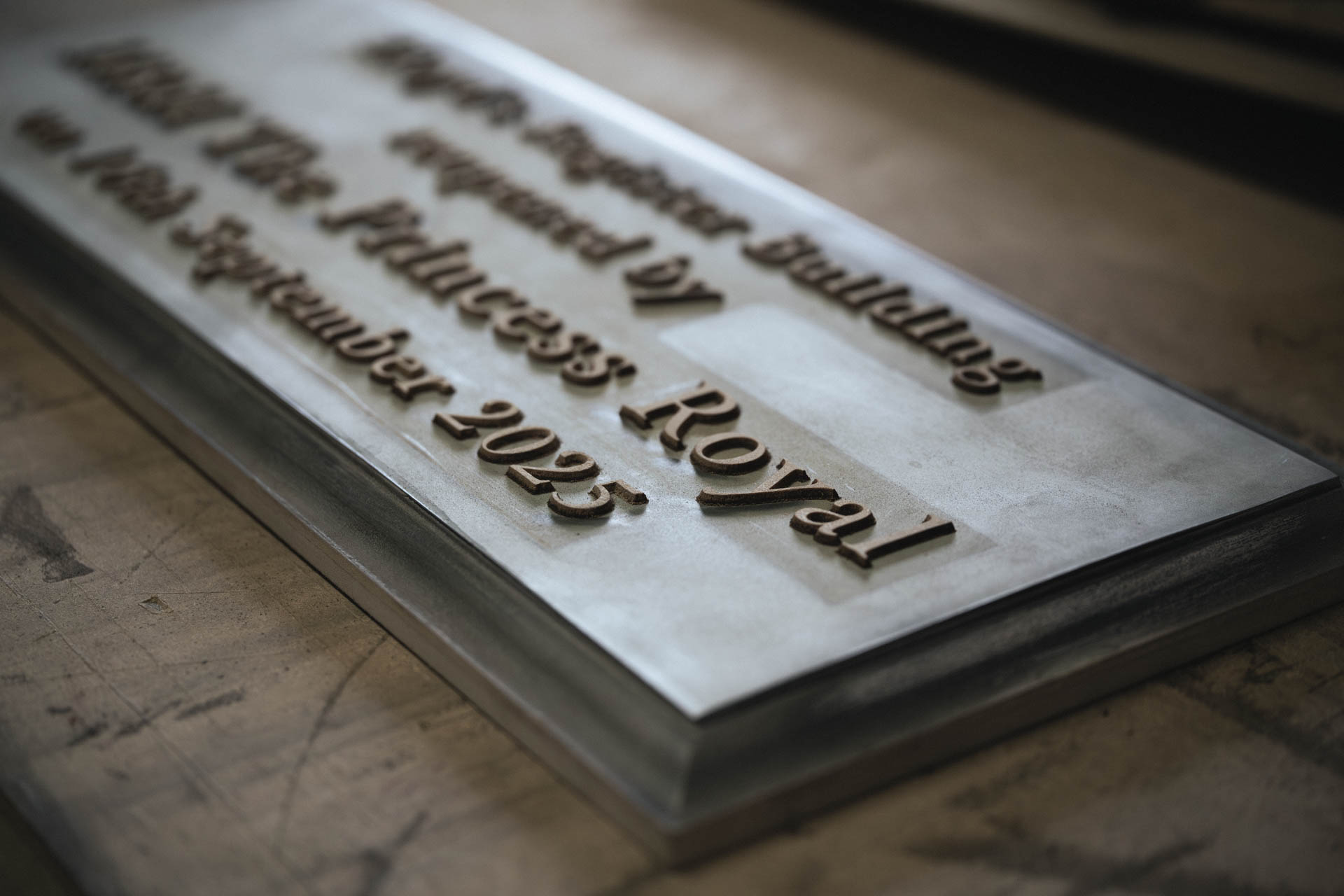 Bronze pattern for a commemorative plaque being crafted for the re-opening of the Lloyd’s Register building, showing raised lettering on a metal surface in a workshop.