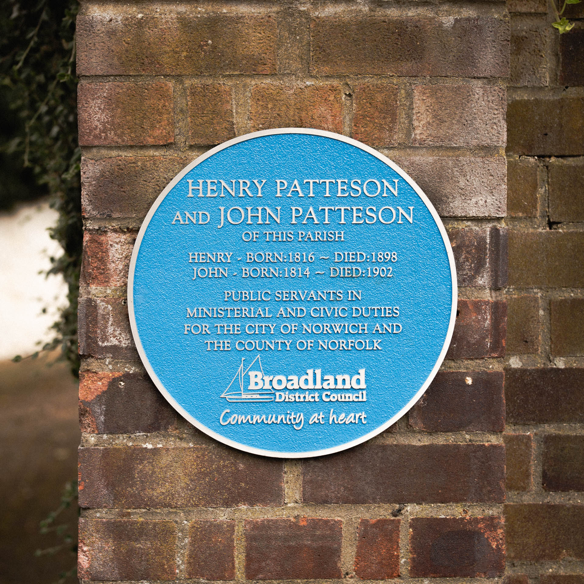 Cast aluminium blue plaque commemorating Henry and John Patteson, public servants in ministerial and civic duties for Norwich and Norfolk. Made by Anglia Sign Casting, the plaque features crisp raised lettering on a textured blue background, with the Broadland District Council logo — a durable and elegant tribute to local history.