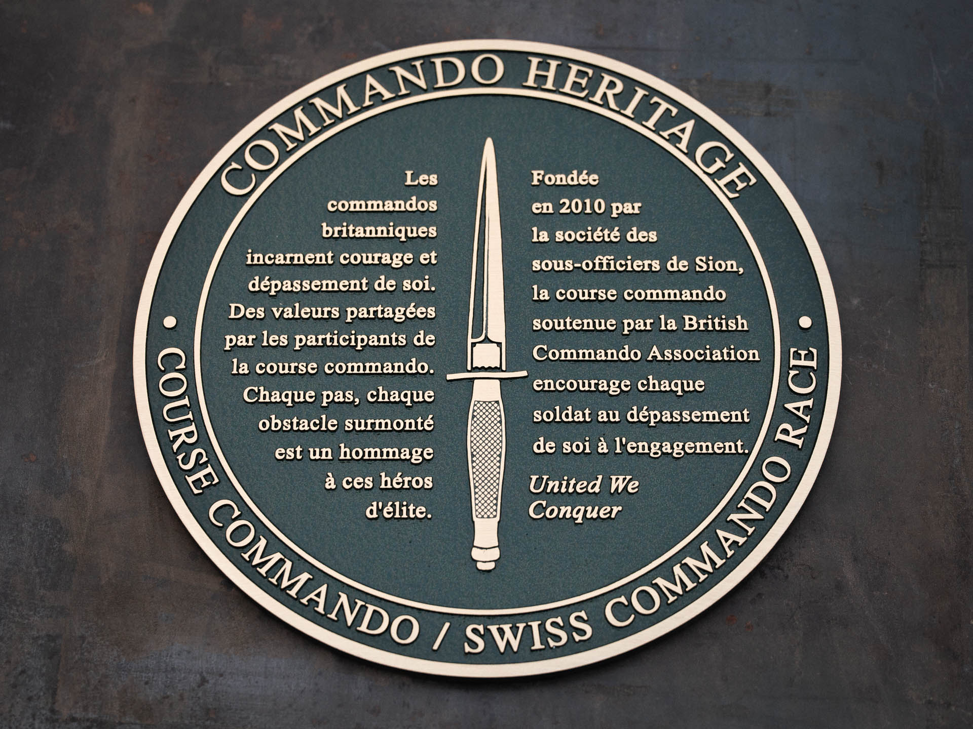 Cast bronze remembrance plaque featuring the Royal Marines Commando logo, part of the Scott Sutherland Project's Commando Memorial Heritage Trail.