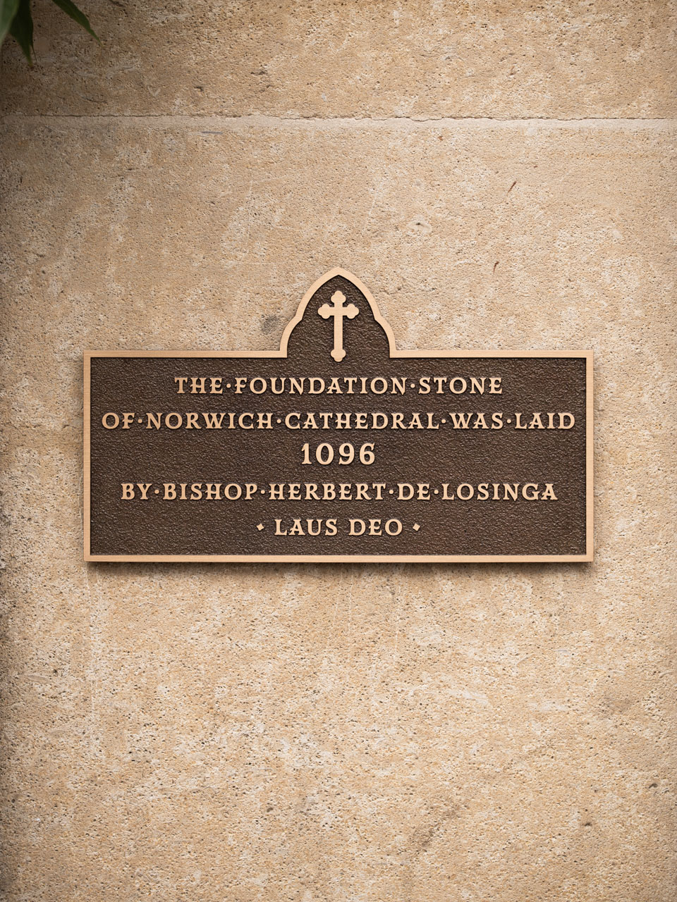 A bronze commemorative plaque marking the date the foundation stone of Norwich Cathedral was laid by Bishop Herbert de Losinga.