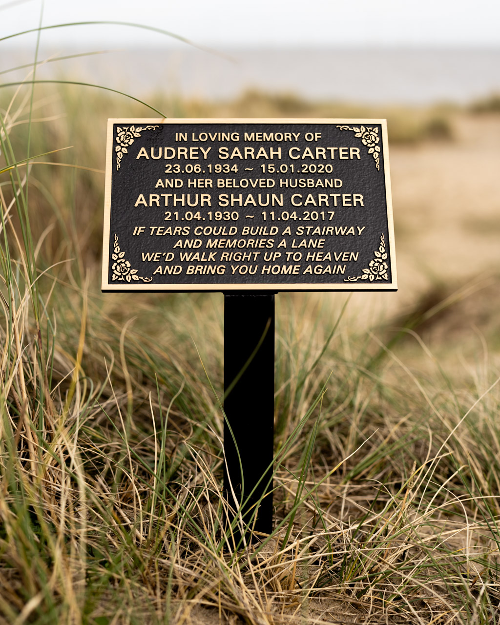 Elegant cast bronze memorial plaque with a black painted background, featuring an integral ground stake for secure outdoor placement. Designed with raised lettering and decorative corner detailing, this weather-resistant plaque provides a timeless tribute for loved ones. Ideal for cemeteries, gardens, and natural memorial settings, offering a lasting and dignified remembrance.