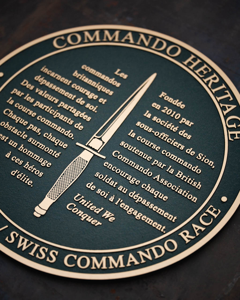 Cast bronze remembrance plaque featuring the Royal Marines Commando logo, part of the Scott Sutherland Project's Commando Memorial Heritage Trail.