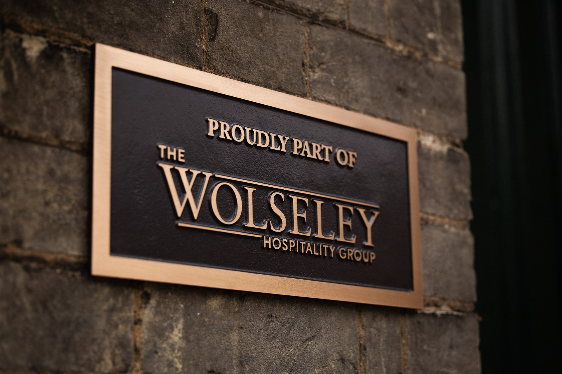 Timeless bronze business signage with raised lettering and a painted background, ideal for businesses seeking premium, bespoke plaques to elevate their brand identity with lasting elegance.