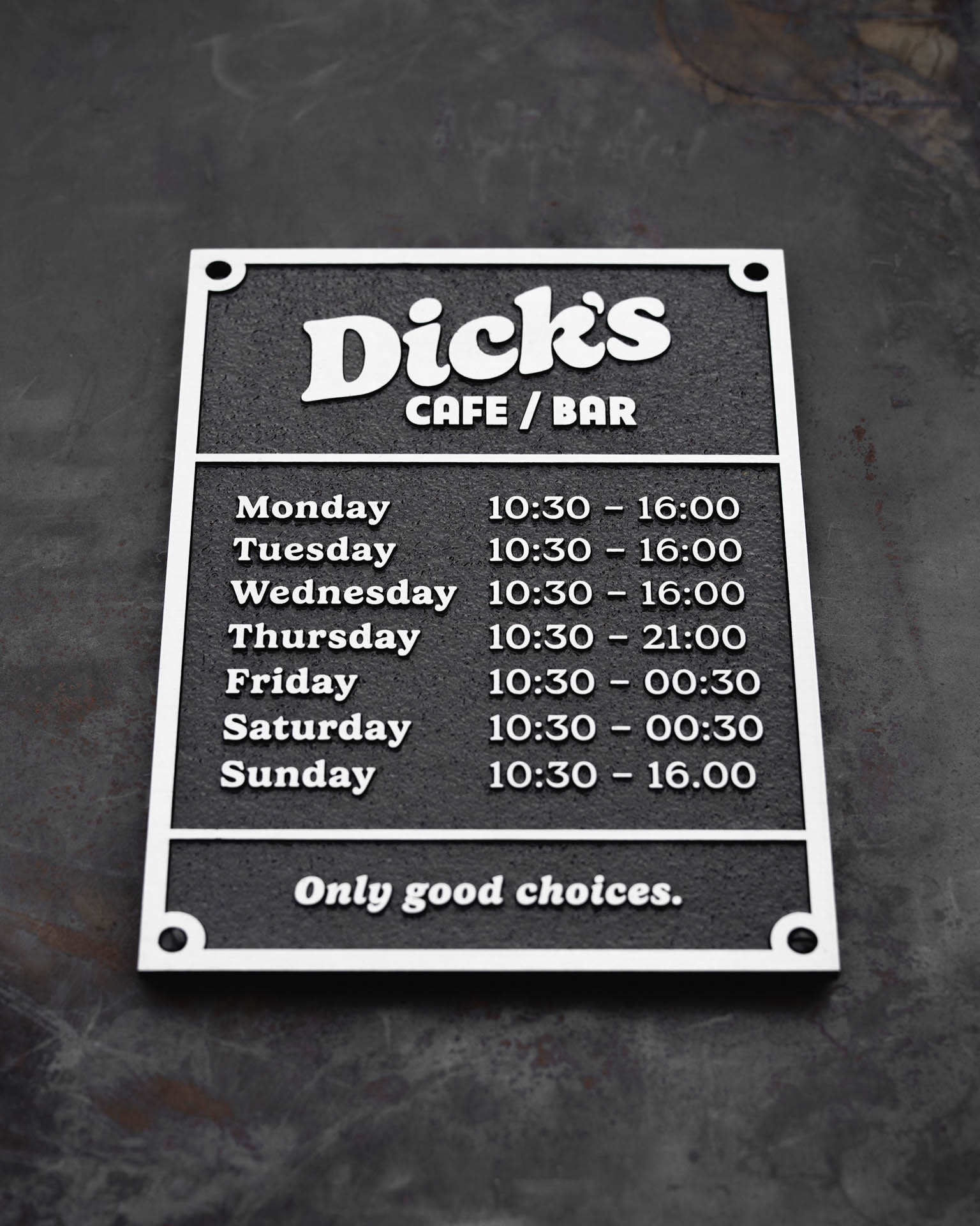 Durable cast aluminium business hours sign for 'Dick’s Café / Bar,' featuring raised silver lettering on a textured black background. Clearly displaying opening times for each day of the week, this weather-resistant plaque is designed for outdoor and indoor use. Custom-made for businesses, cafes, and restaurants, offering a stylish and long-lasting signage solution.