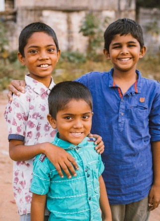 Children smiling outside their home in an Angel House community in India”