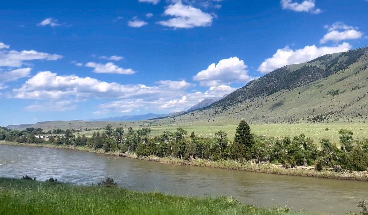A custom home designed by Yellowstone Architects with the Montana Big Sky above it and sage brush outside of Gardiner Montana
