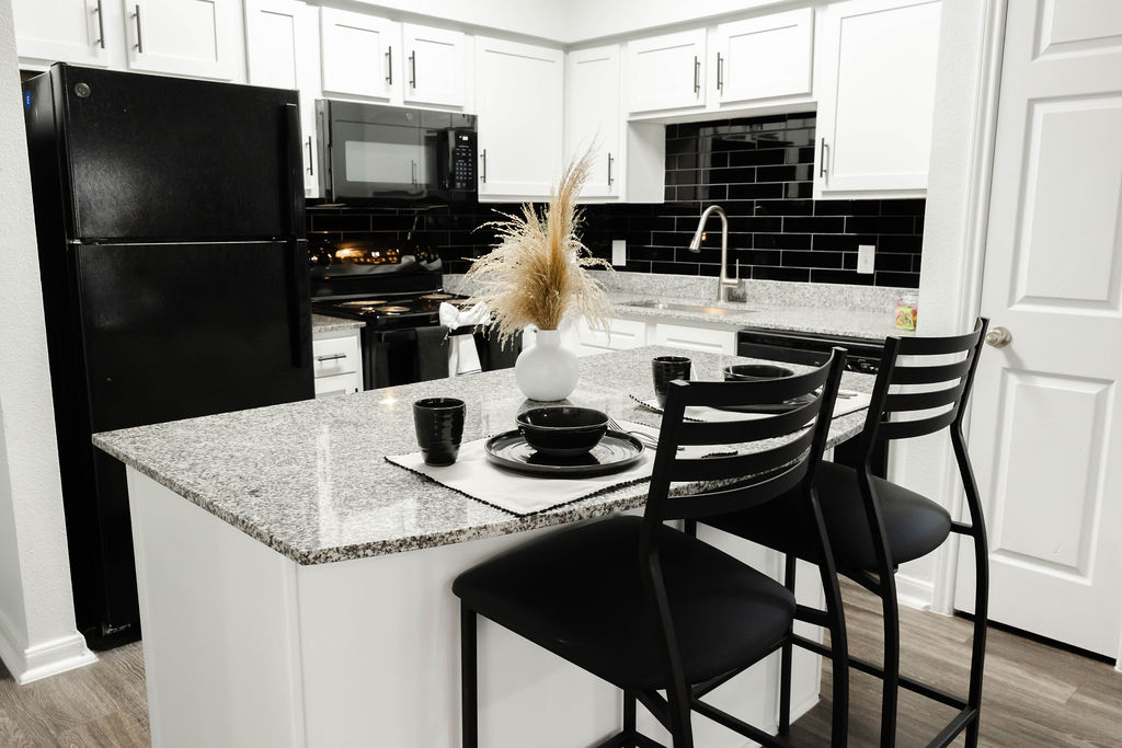 Kitchen island and kitchen with black appliances