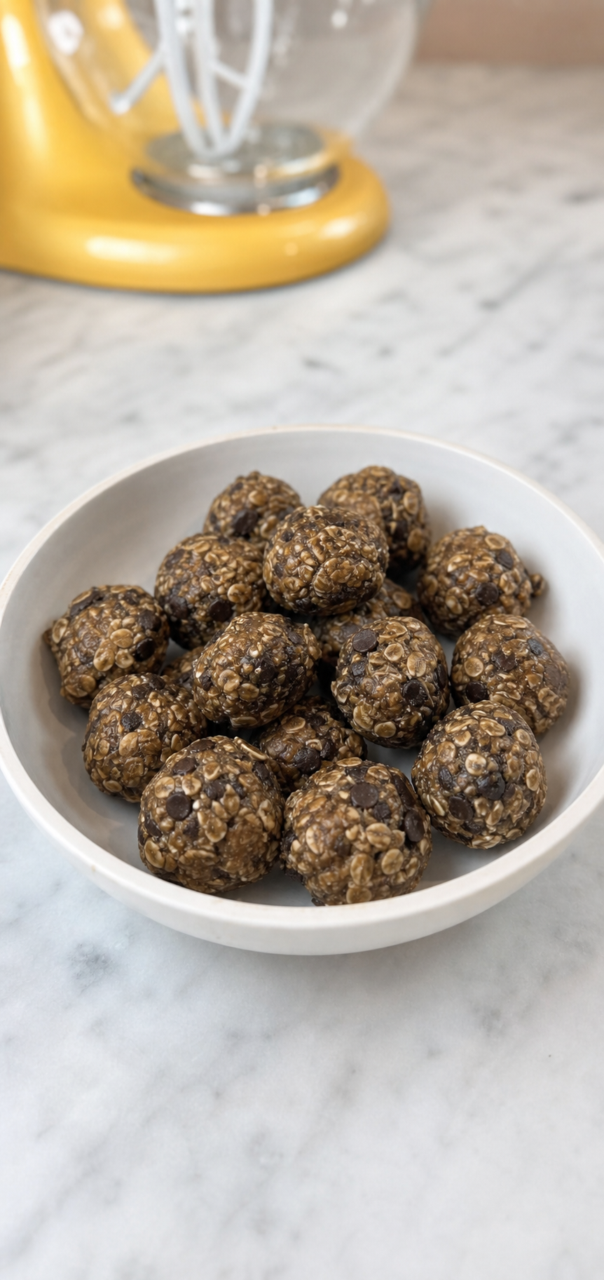 Candid homemade oat and chocolate chip energy bites in a white bowl