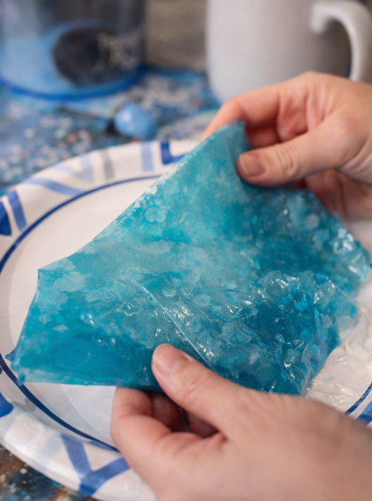 holding and unwrapping a blue fruit roll up