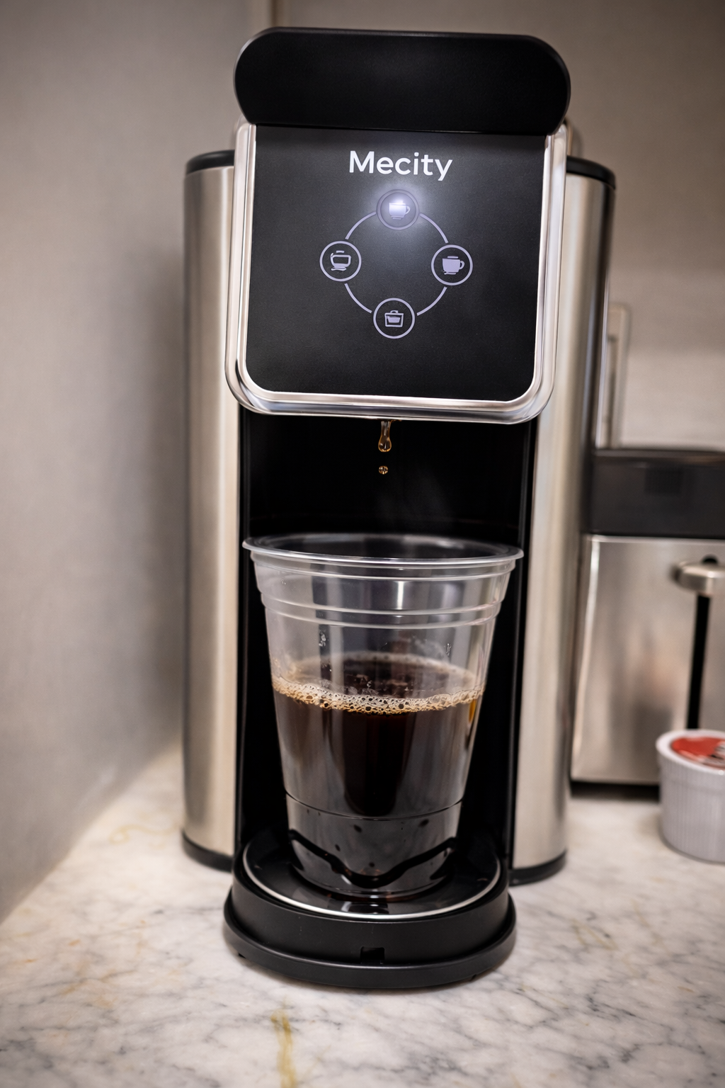 Coffee brewing into a clear cup from a Mecity coffee machine on a marble countertop with soft professional lighting.