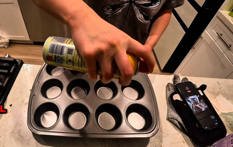 spraying the muffin pan