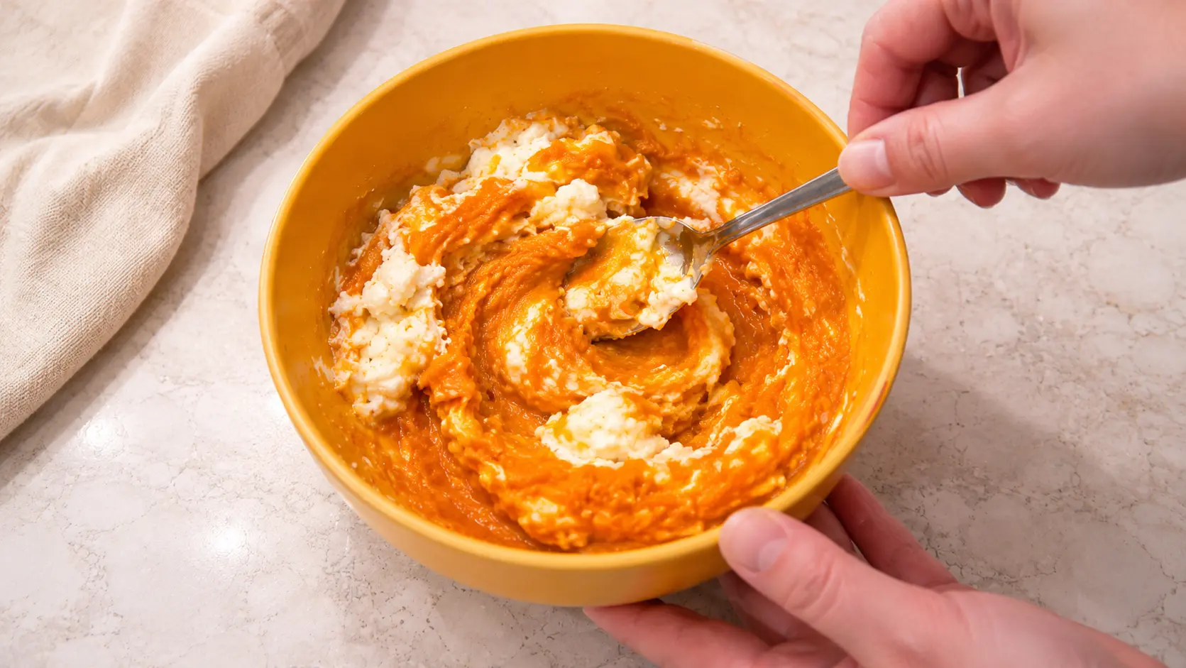 using the spoon to mix cream cheese, pumpkin, and egg