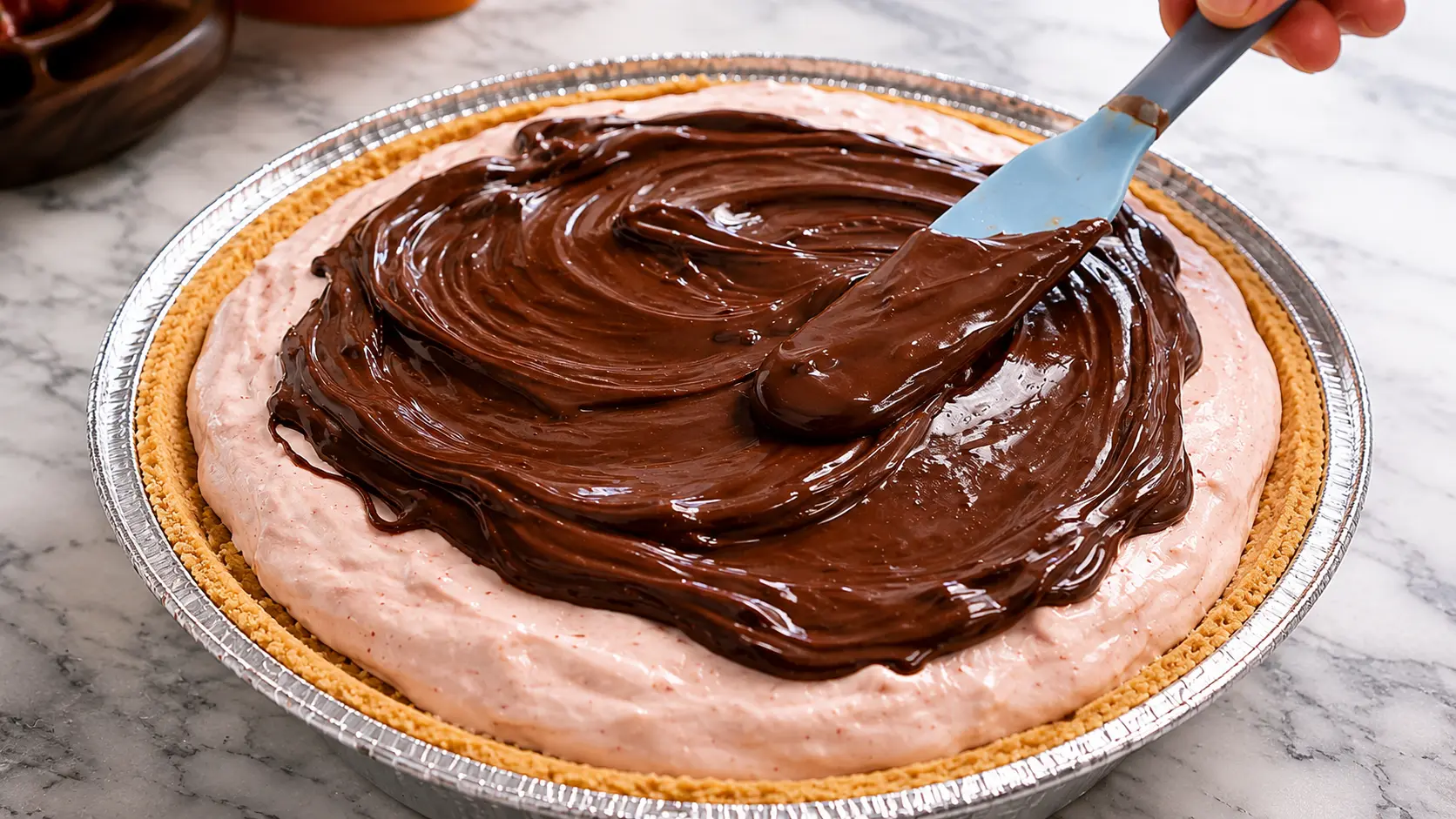 Hyper-realistic close-up of melted chocolate being smoothly spread over a creamy strawberry cheesecake filling in a pie crust, with a spatula creating glossy swirls under soft professional lighting on a marble countertop.
