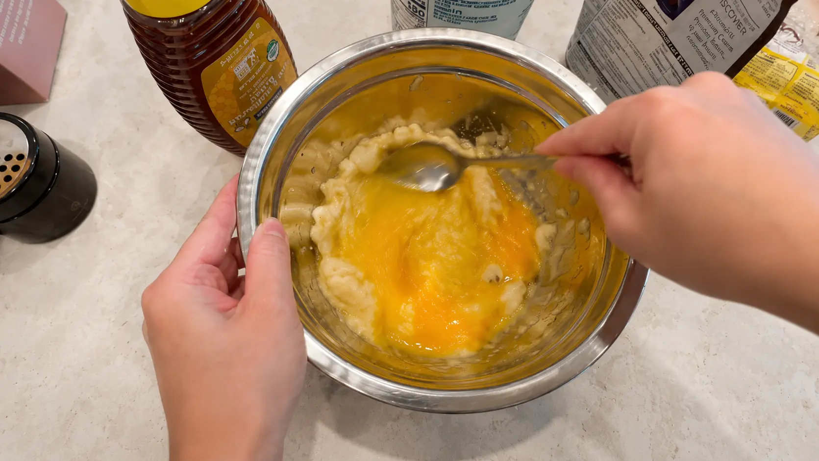 Combining eggs and mashed banana for flourless high protein brownies. This mixture creates a moist, fudgy texture before adding cocoa powder and other ingredients.