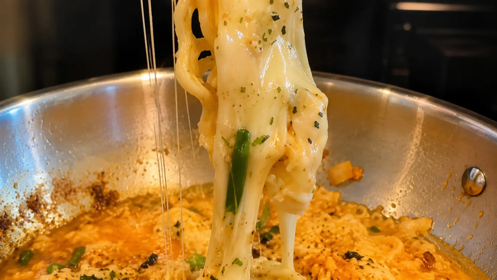 Cheesy ramen noodles with gooey mozzarella cheese pull, green onions, and furikake in a skillet.