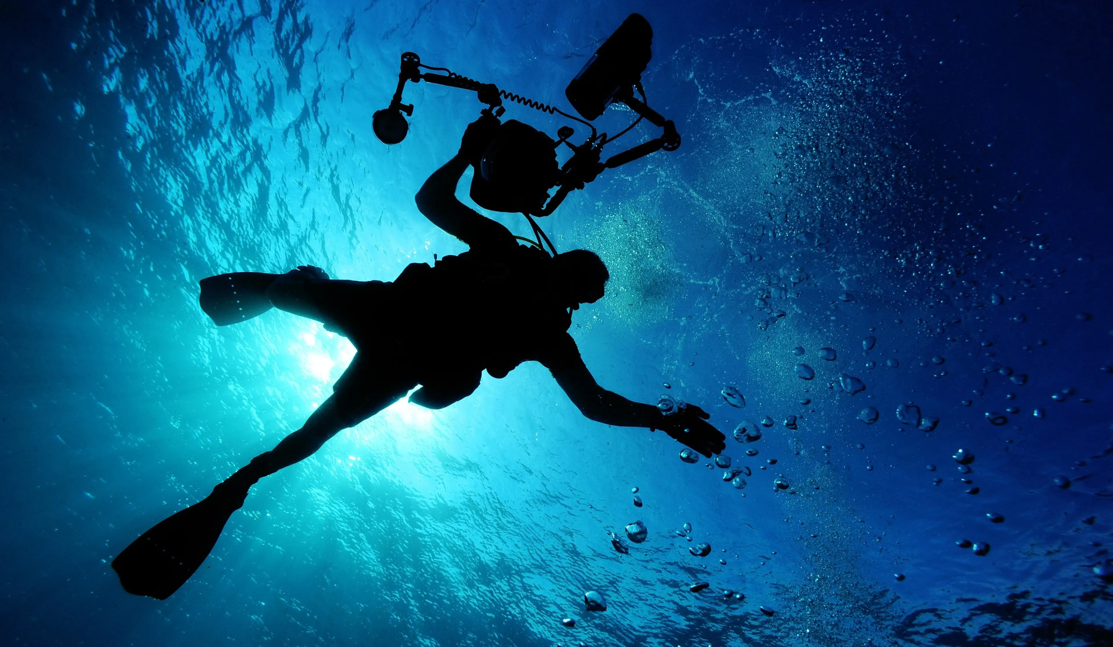 scuba divers with underwater camera in the blue