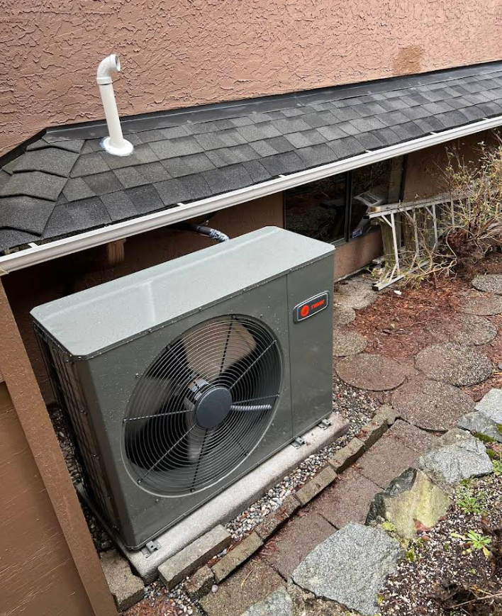 Technician servicing a residential heat pump outdoor unit