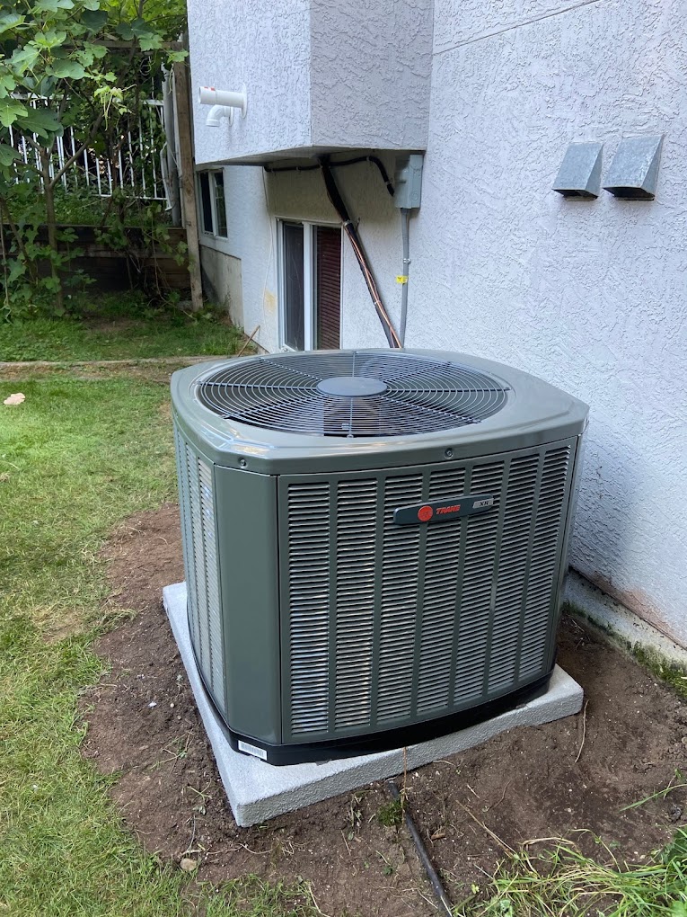 Central air conditioner condenser unit being installed at a home