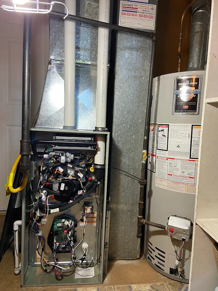 Furnace repair technician diagnosing a gas furnace in a Burnaby home
