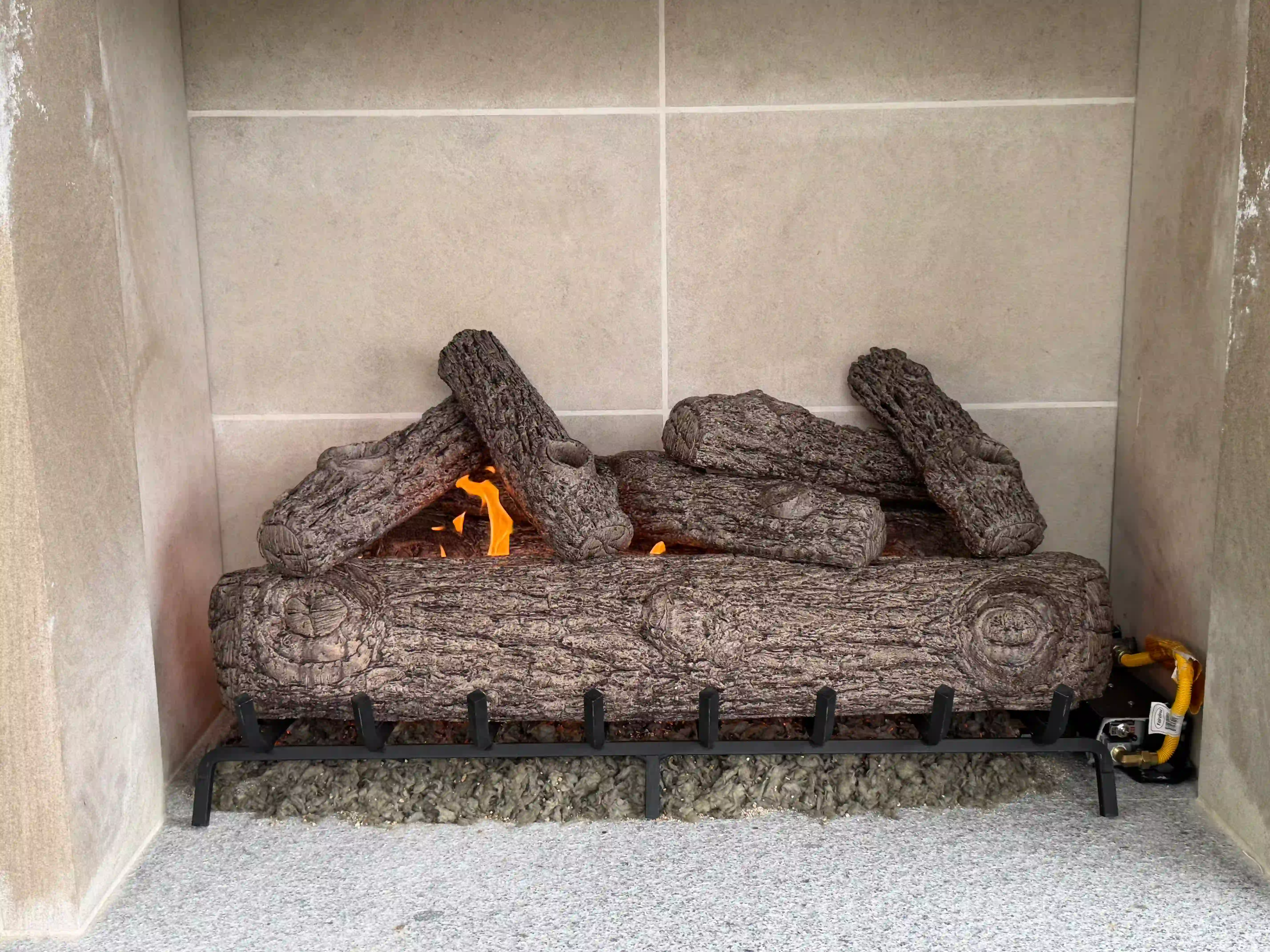 Gas fireplace insert with glass panel removed during cleaning and service