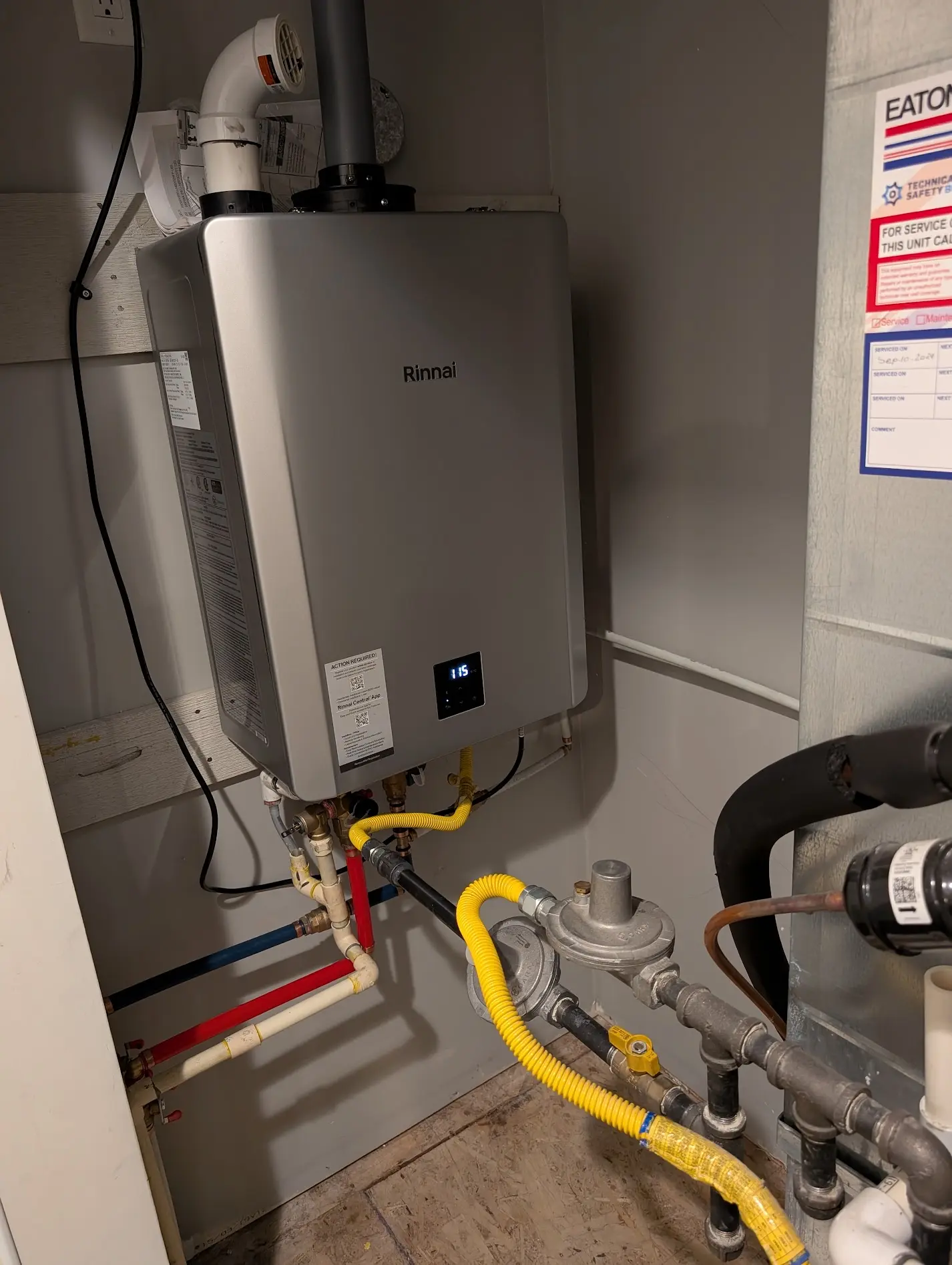 Tankless water heater wall-mounted unit during repair and diagnostic service in Burnaby