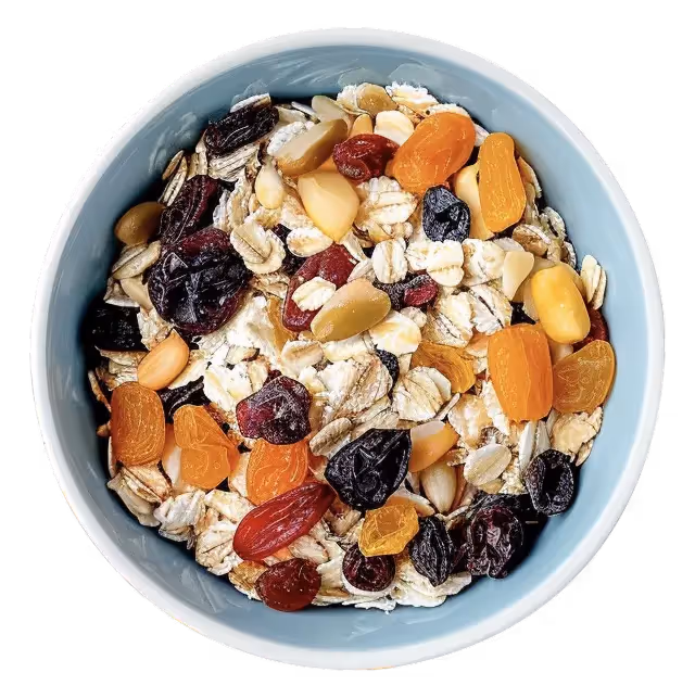 A color photo of a bowl filled with oats and various dried fruits like apricots and raisins.