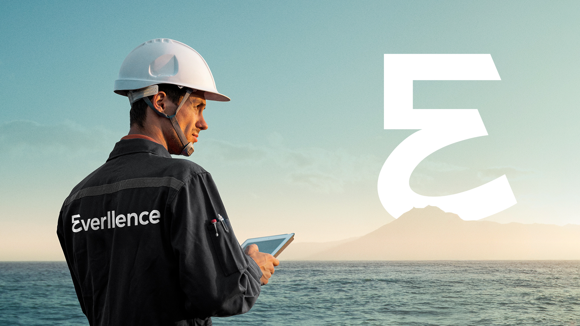 Alt-Text: Seitenansicht einer professionell gekleideten Frau in einer hellblauen Bluse, die ein Tablet benutzt, in einer modernen Industrie- oder Technikhalle; links im Bild befindet sich eine groĂe rote FarbflĂ€che.