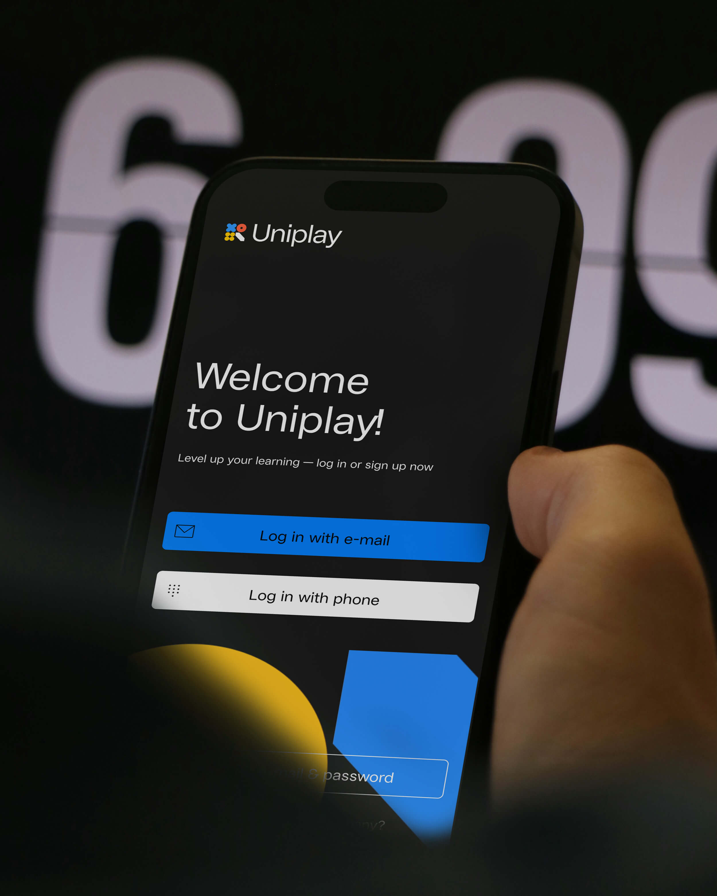 Smartphone displaying the Uniplay app login screen with options to log in with email or phone.