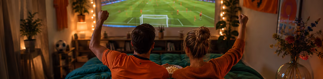 koppel kijkt vanuit bed naar oranje wk wedstrijd
