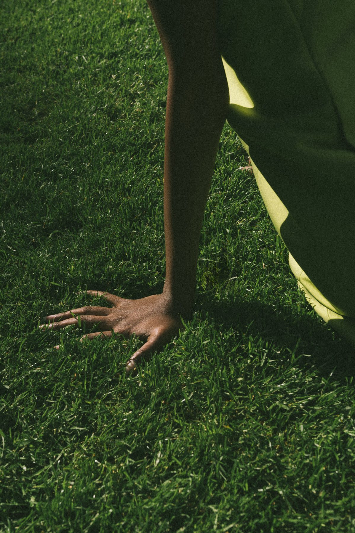 Hand pressed into green grass — natural healing