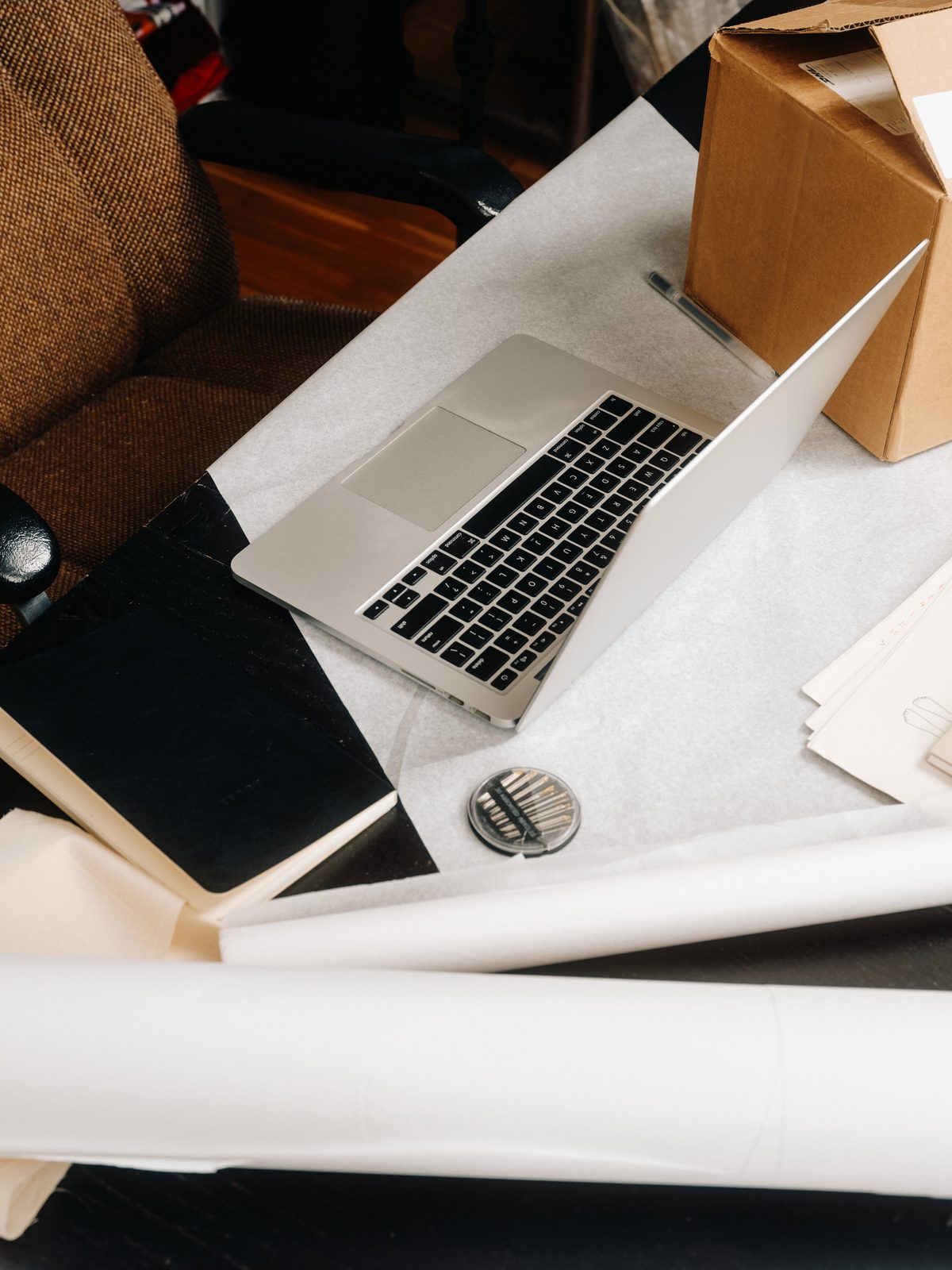An open laptop and papers on a desk — researching prolotherapy evidence
