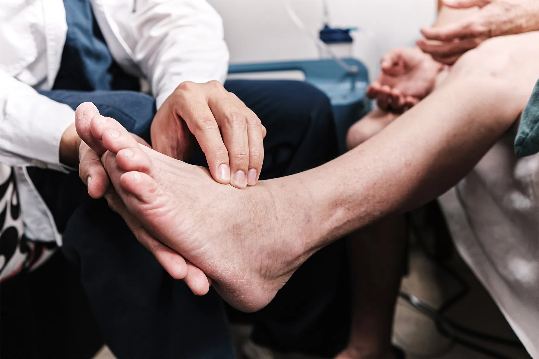 Doctor checking a patient’s foot for drug-induced neuropathy pain issues and recommending him treatment options after.