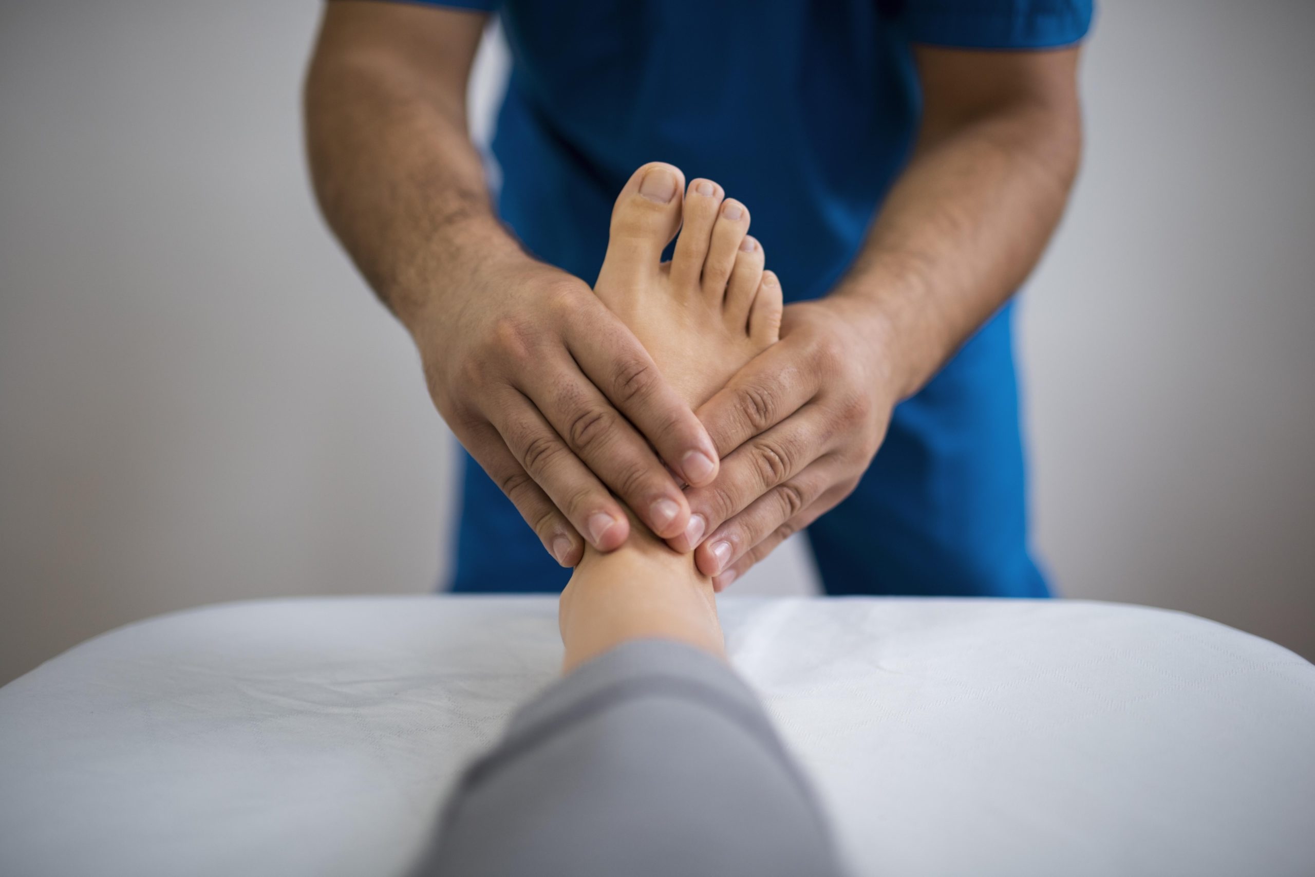 A therapist massaging a patient’s foot suffering from detox-related nerve pain caused by heavy metal toxins.