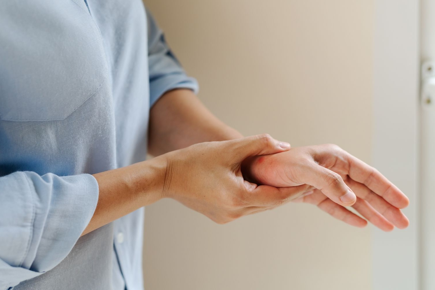 Person holding their wrist due to detox-related peripheral neuropathy pain or discomfort, seeking for relief.