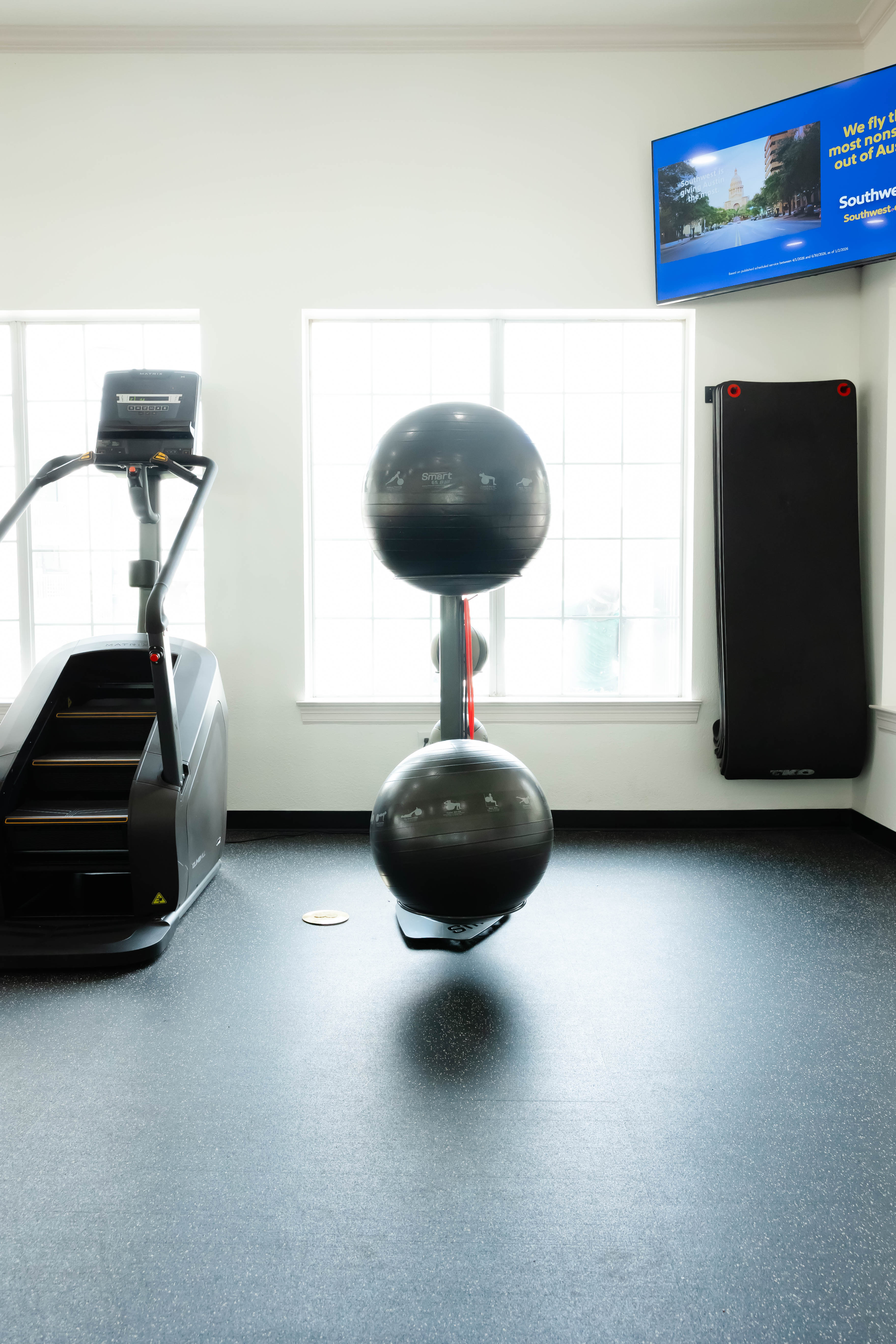 Gym with tv, yoga balls, and stair master