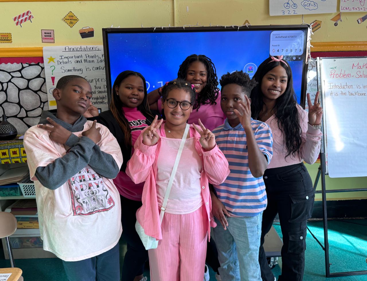 Students and teacher posing together during breast cancer awareness day