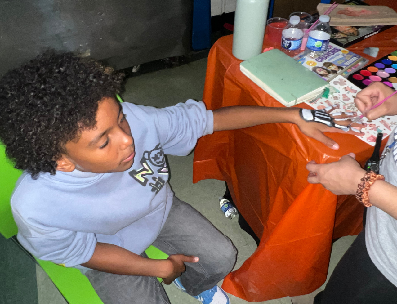 Student getting hand painted at a school art activity