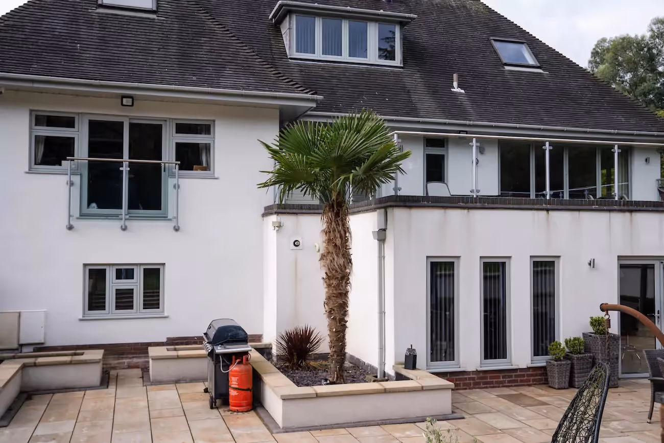 A view from the patio of a large white newly converted home