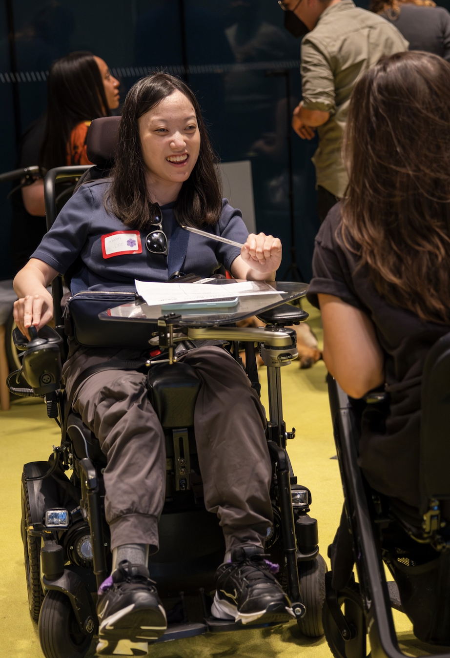 a young women who uses a wheelchair at a making space event in conversation